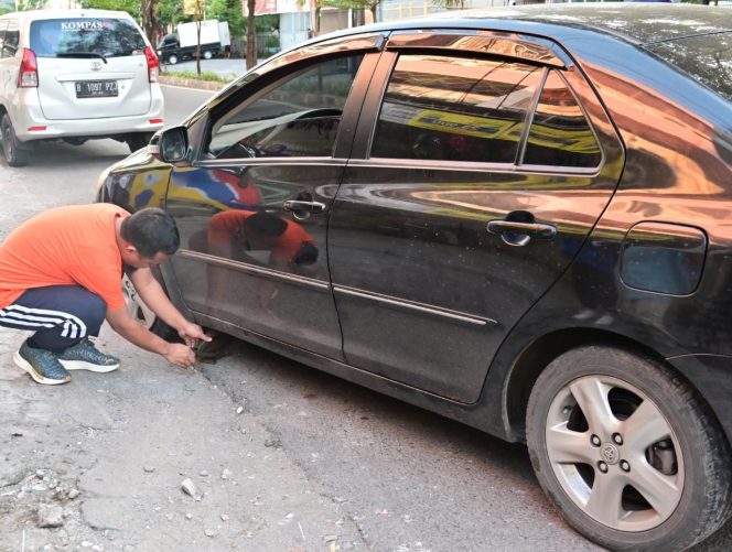 
 Jalan Pagi, Gubernur Andi Sudirman Bantu Seorang Ibu Perbaiki Ban Mobil Bocor